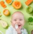Baby surrounded by healthy food to eat